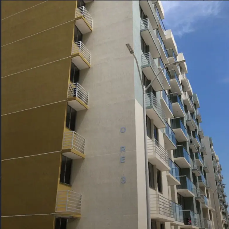 Dos edificios de apartamentos adyacentes en colores contrastantes, uno dorado y otro blanco, con balcones.
